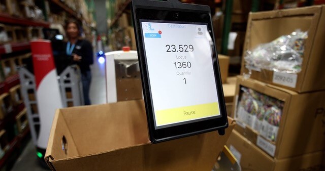 Screens attached to mobile robots identify picking location and quantity to be picked.